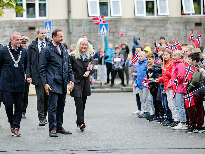 Kronprinsparet møter barn ved Allanengen skole som står gruppevis i skolegården. Foto: Berit Roald / NTB